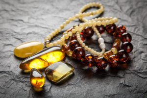 Amber jewelry on grey background Jubiler online – Coraz większa ilość złota, także biżuterii, jest sprzedawana online